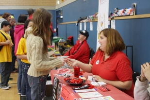 A Schweinfurt Community member assists a youth at the School Age center during Kinderfest 2013.